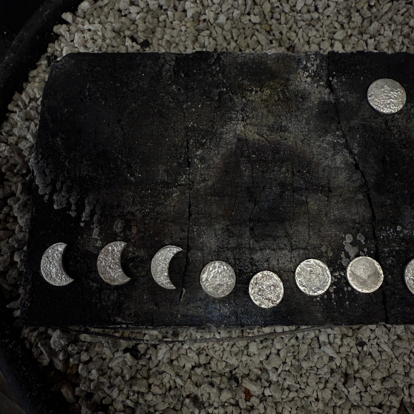 Sterling silver moon earrings on a charcoal block