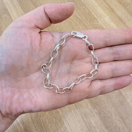 A chain bracelet held in a hand
