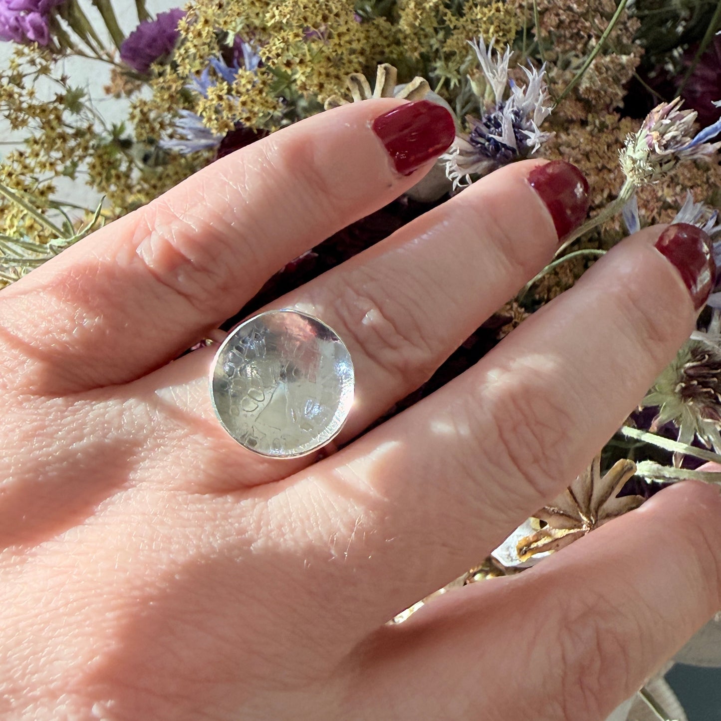 Hand with a ring holding dried flowers