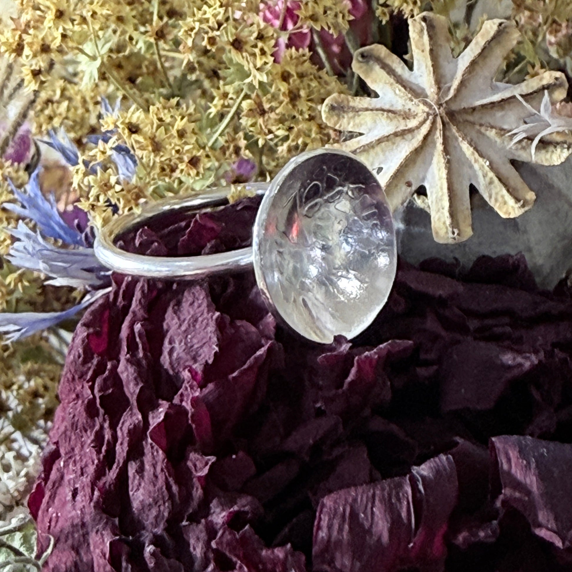 Sterling silver dished ring on dried flowers