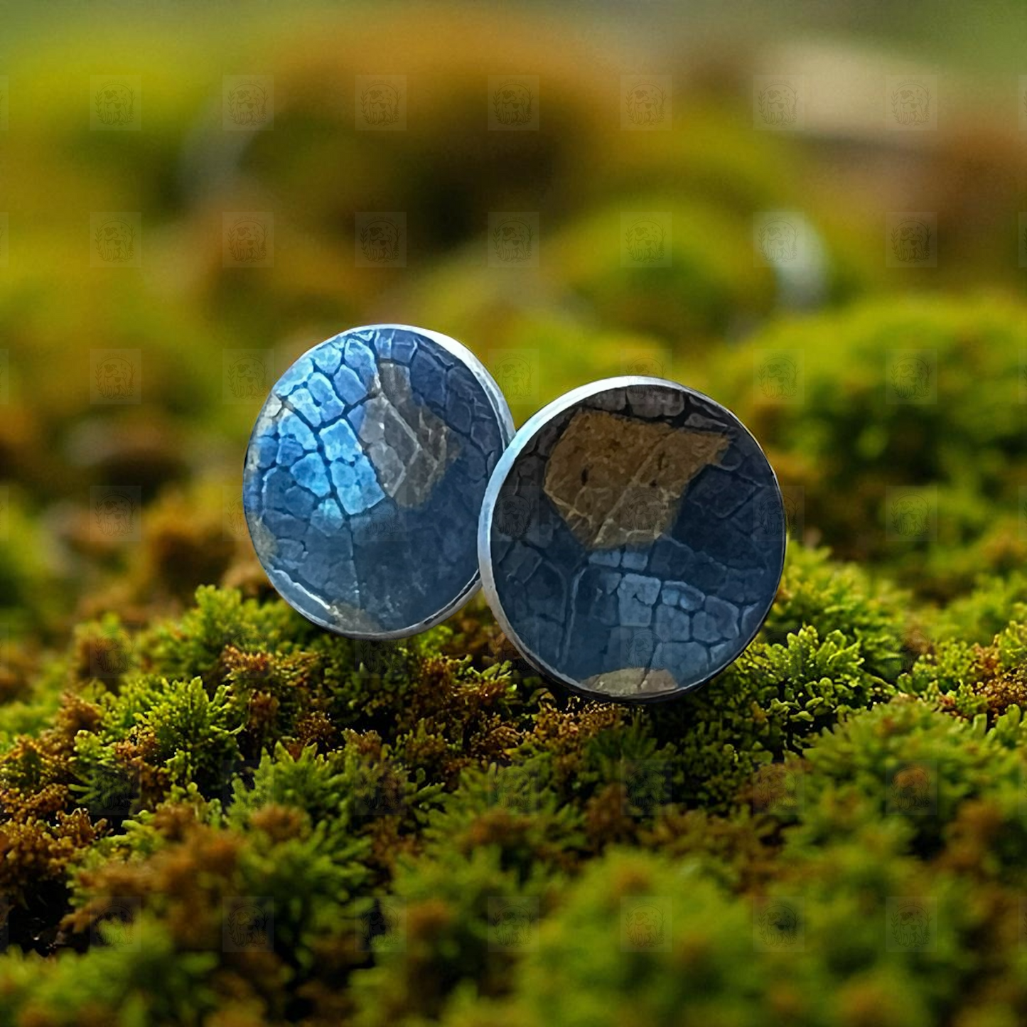 Silver earrings on a bed of green moss