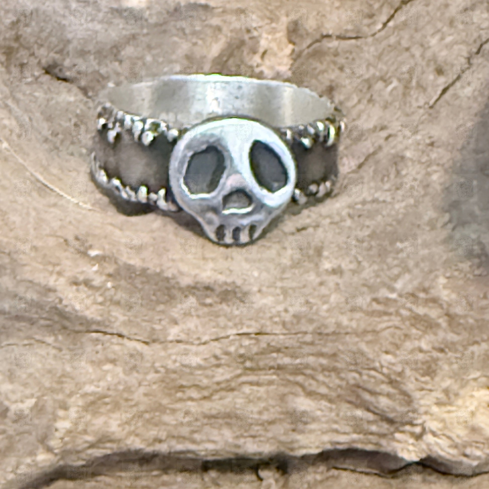 Silver ring with a friendly skull on a stone background