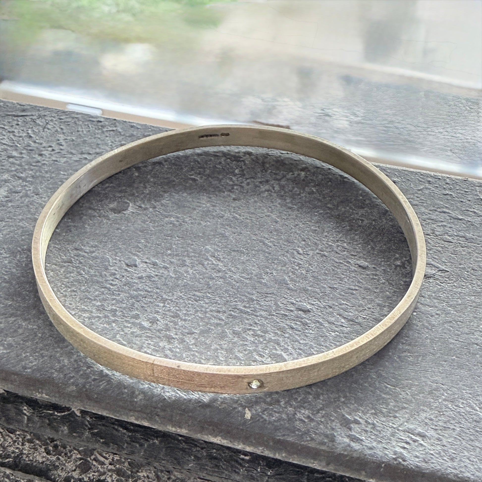 Sterling Silver bangle on a textured surface