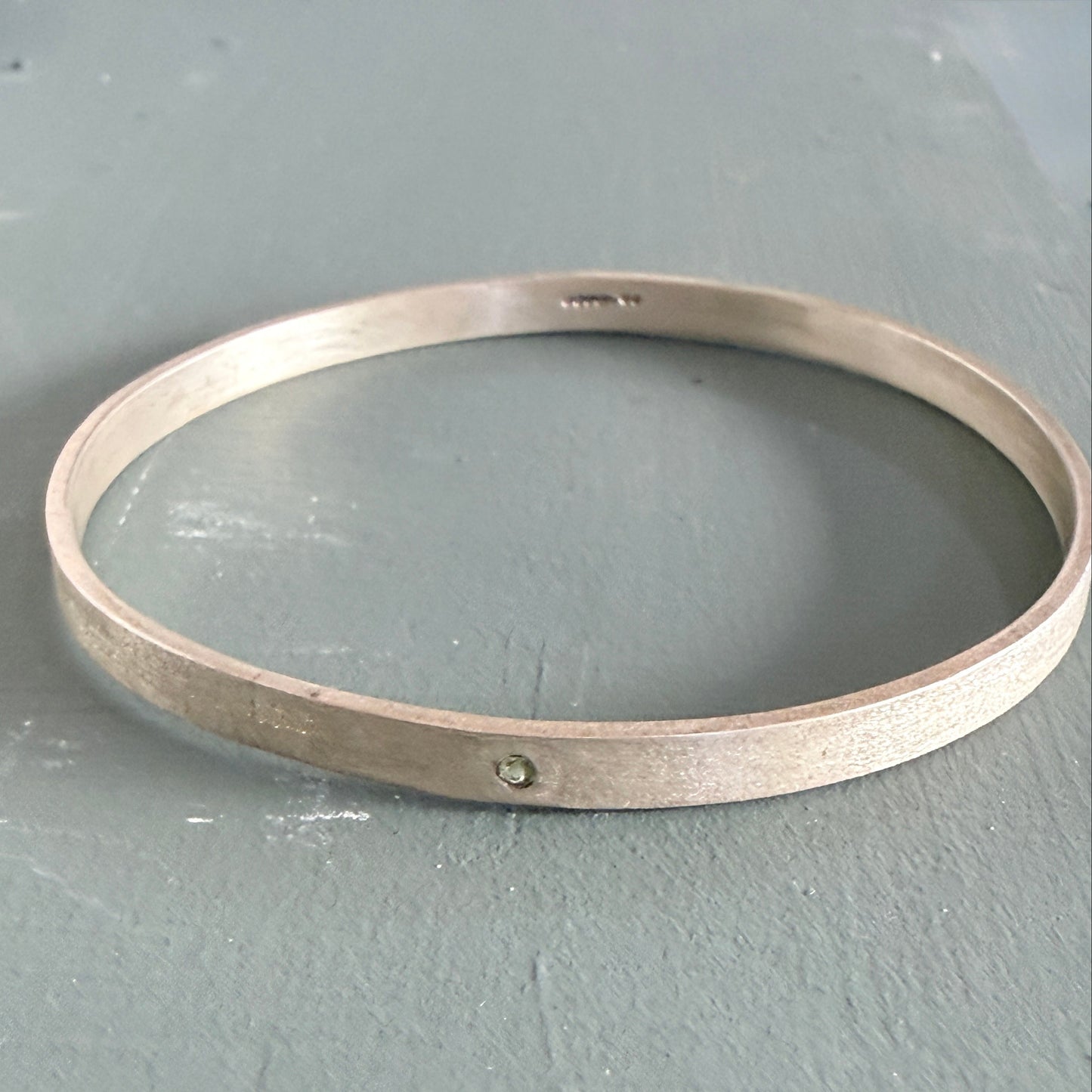 Sterling Silver Bangle on a gray surface