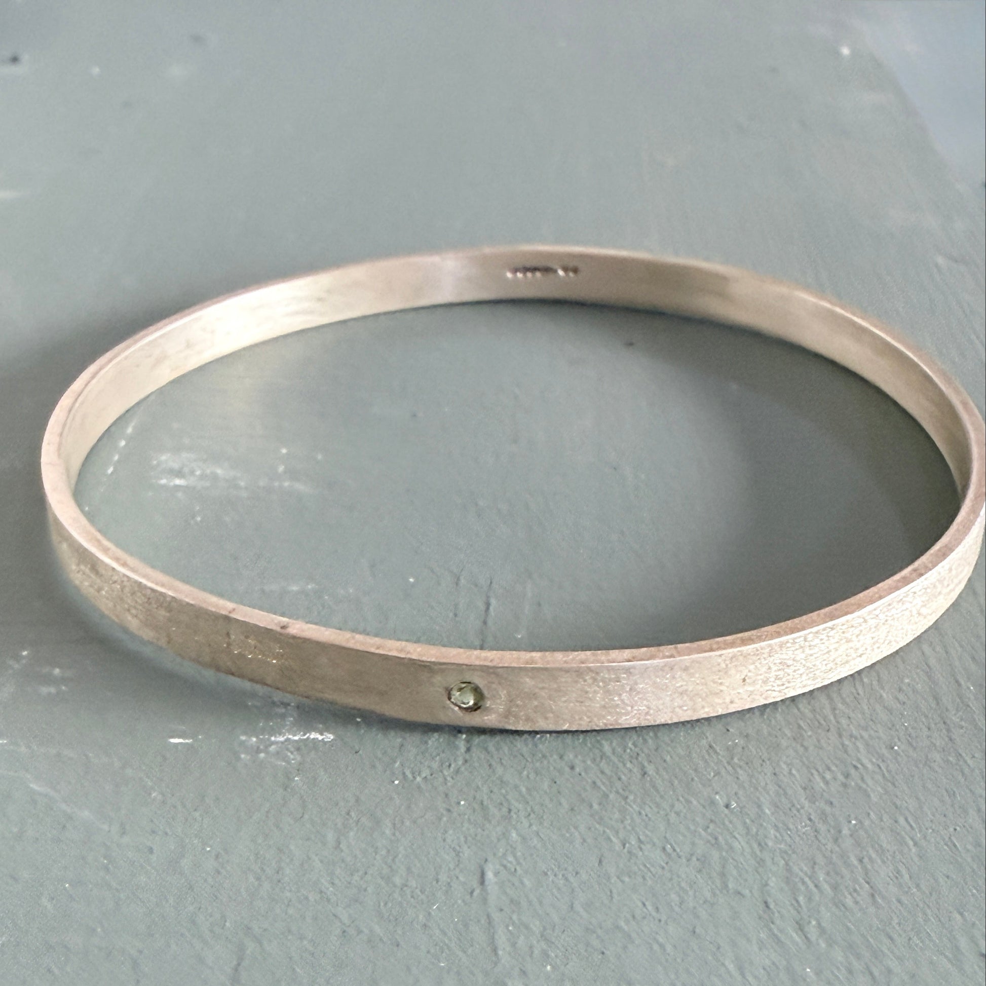Sterling Silver Bangle on a gray surface