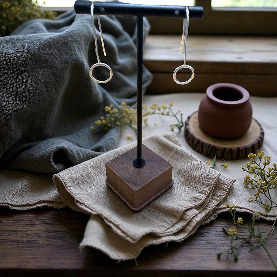 Pair of earrings on a wooden stand with a rustic background