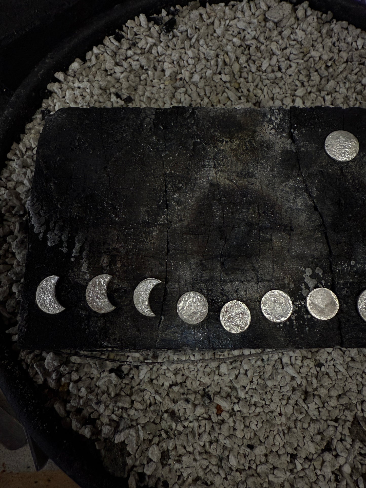 Sterling silver moon earrings on a charcoal block