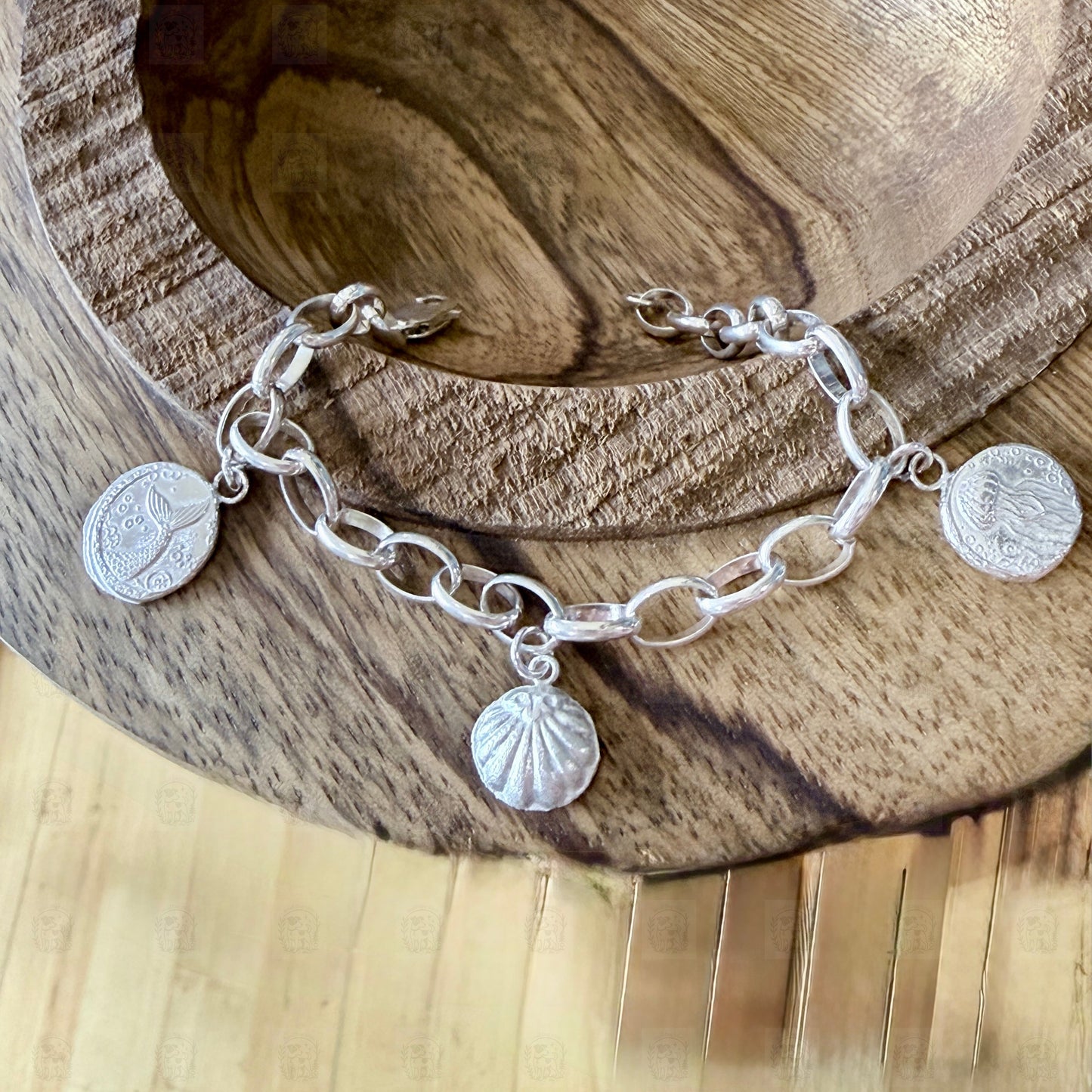 A sea themed charm bracelet on a wooden background