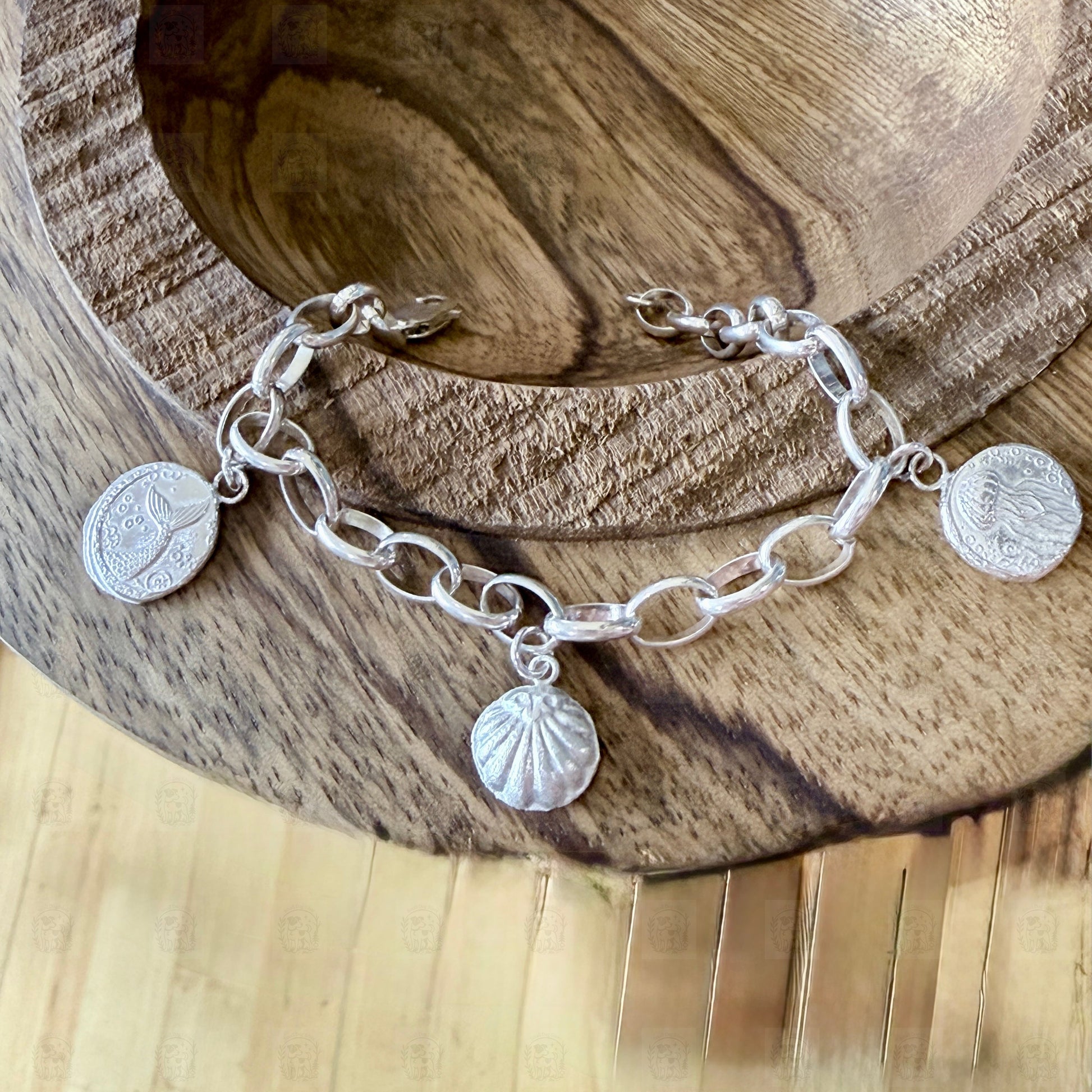 A sea themed charm bracelet on a wooden background