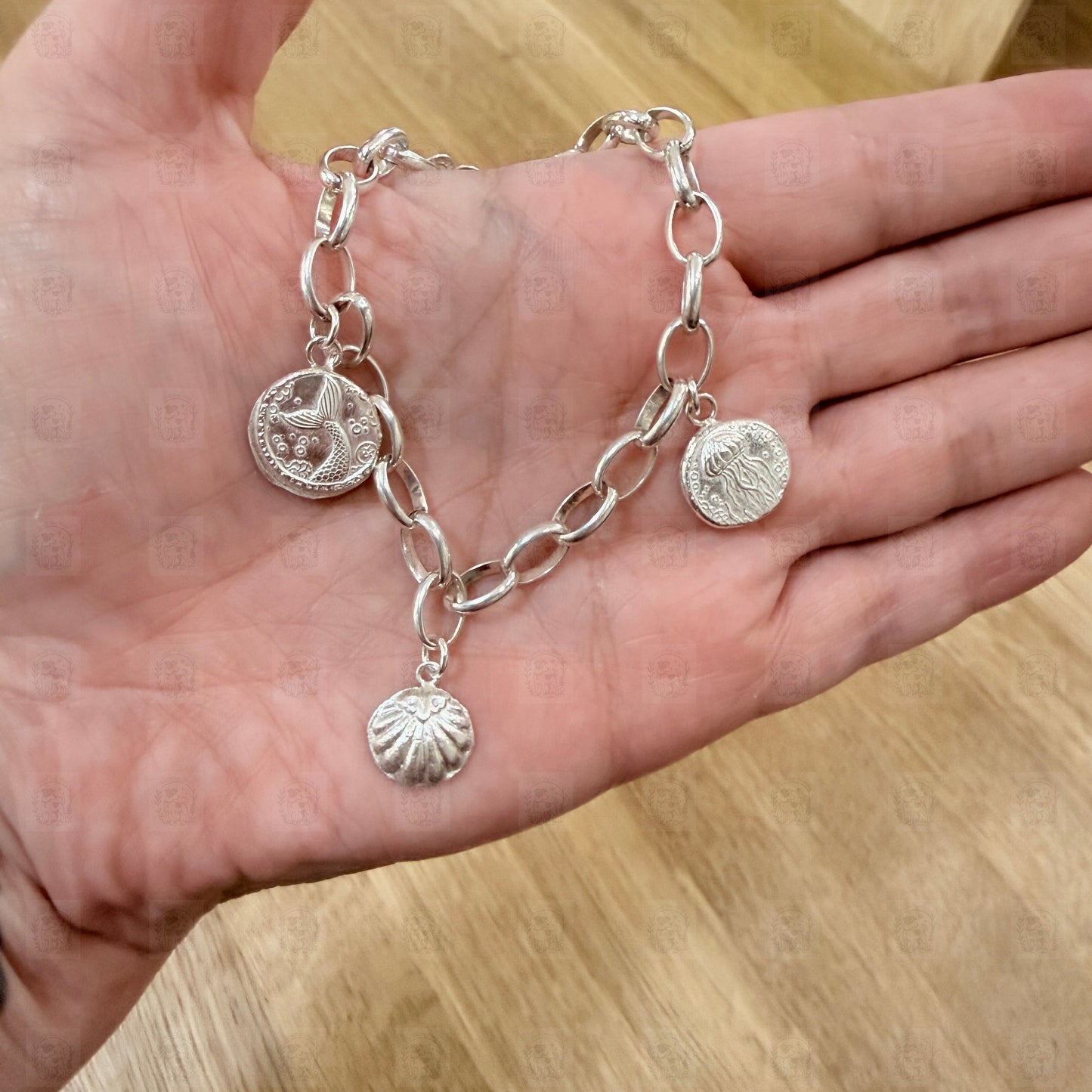 A charm bracelet held in a hand