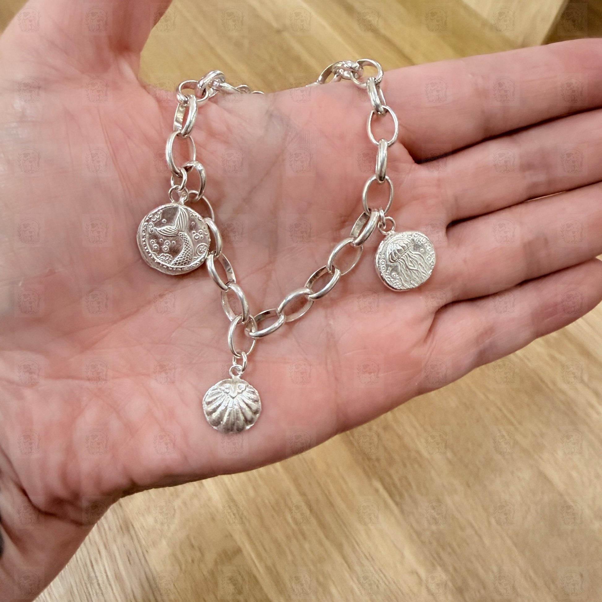 A charm bracelet held in a hand