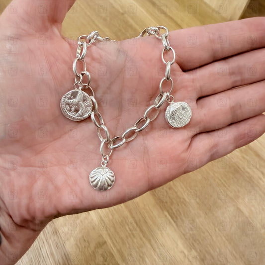 A charm bracelet held in a hand