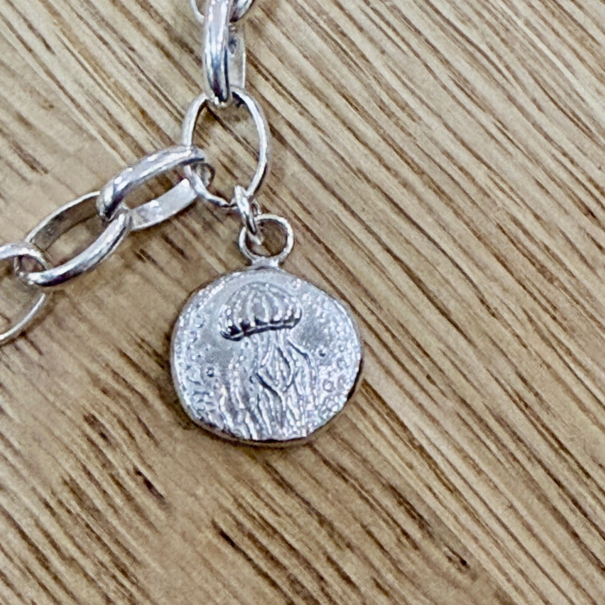 A close up of a jellyfish charm on a wooden background