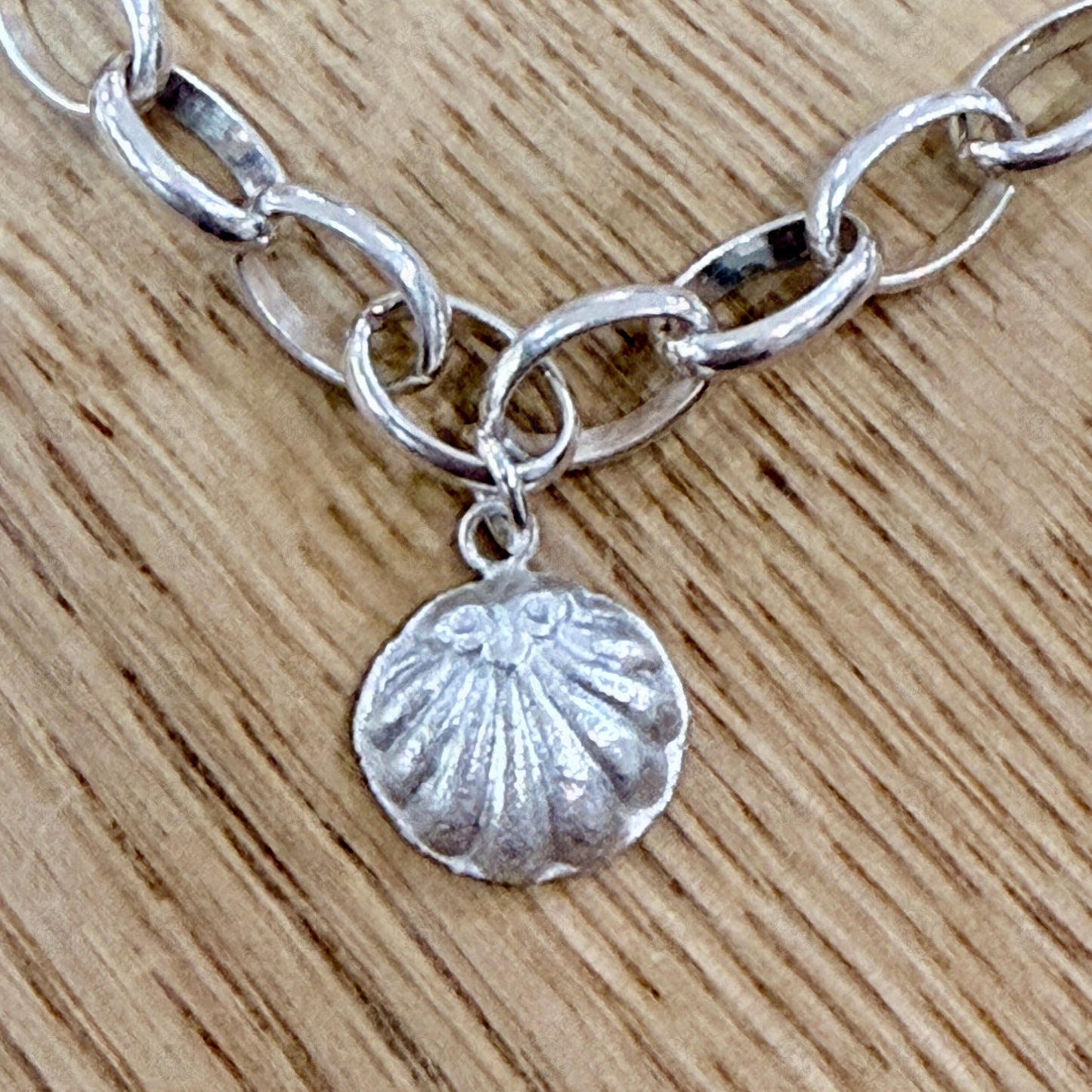 A close up of a shell charm on a wooden background