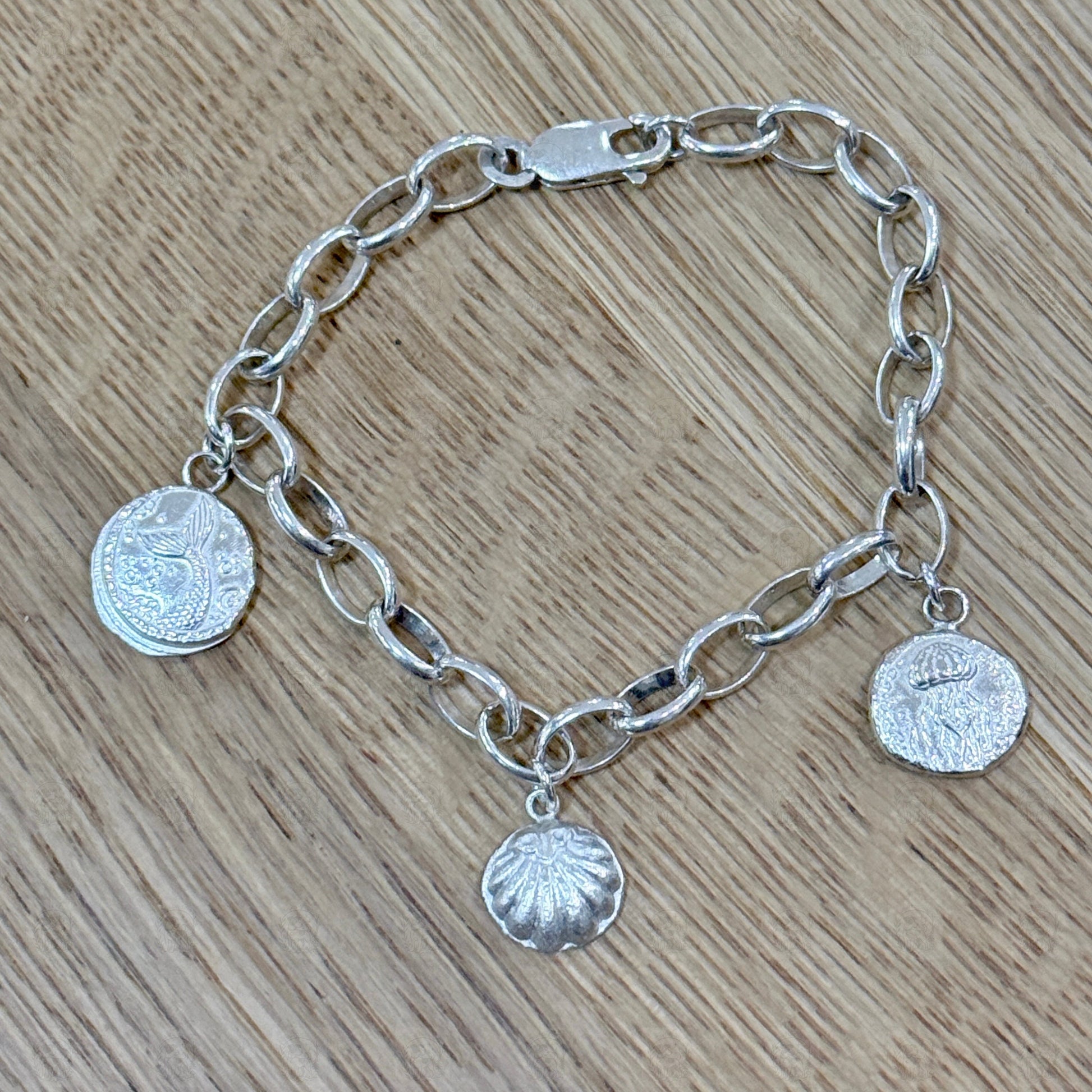 A sea themed charm bracelet on a wooden background