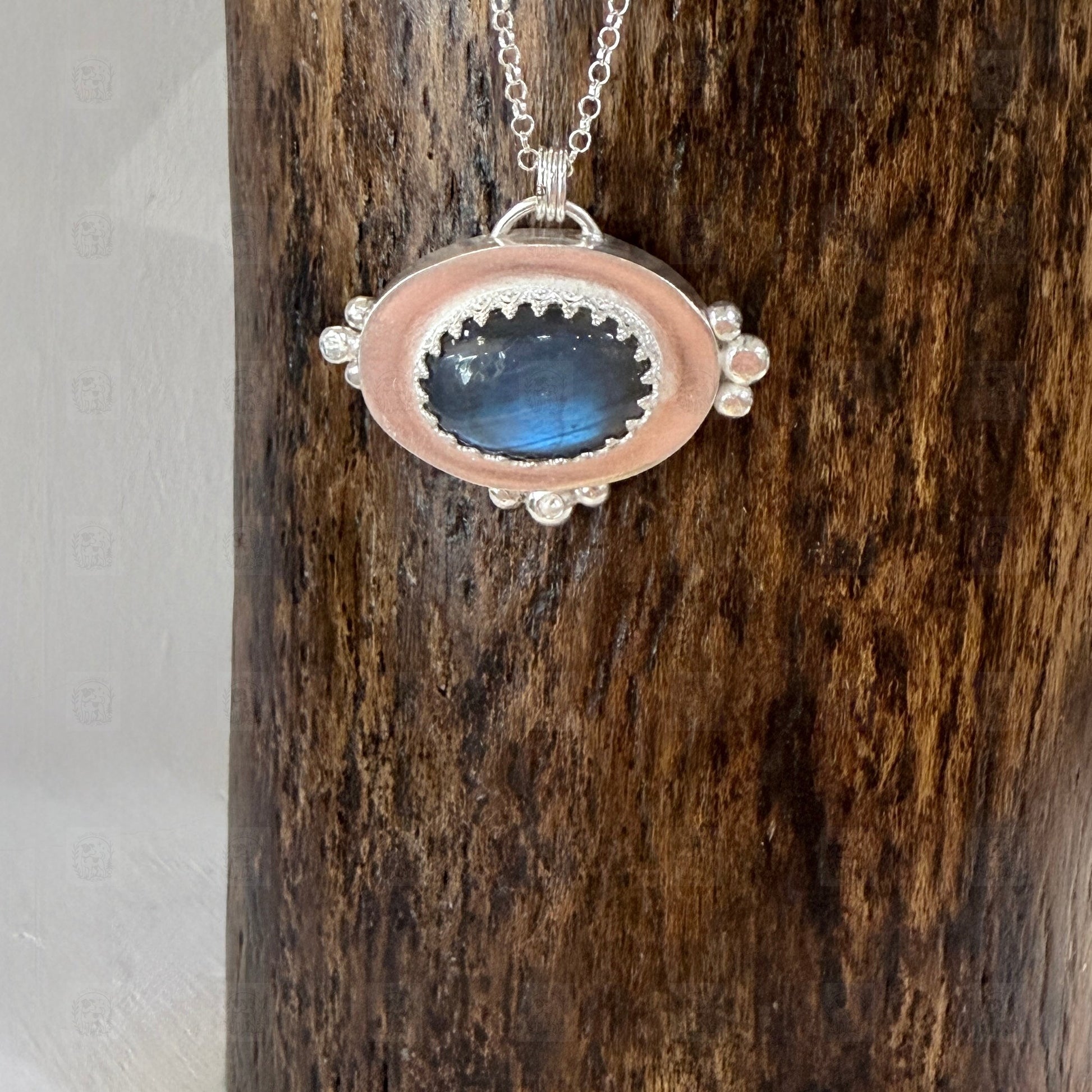 A sterling silver and labradorite pendant on a wooden background